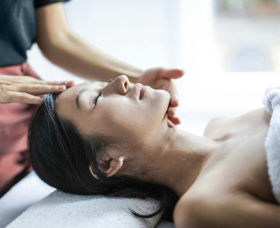 Woman receiving a relaxing facial massage at a spa.
