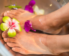 Relaxed feet adorned with vibrant flowers for a spa treatment.