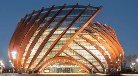Architectural structure with wooden arches illuminated at night.