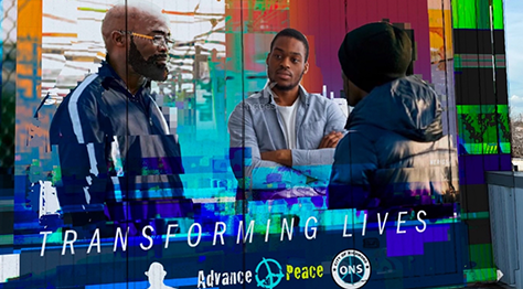 Three people engaged in a thoughtful conversation indoors with a colorful overlay.