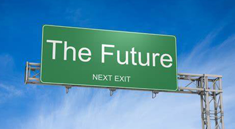 Highway sign reading 'The Future, Next Exit' against blue sky.